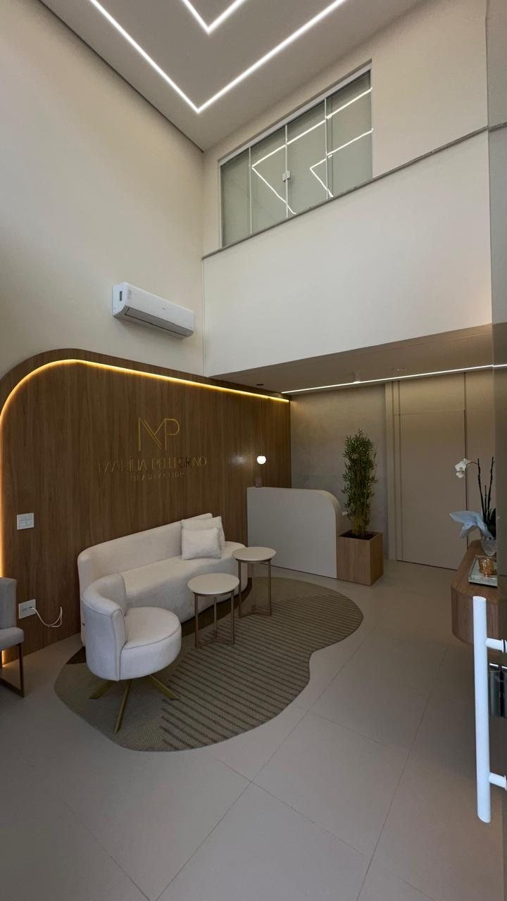 Sala de espera com pé-direito duplo e mobiliário claro